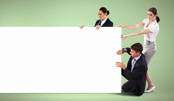 Image of three young people holding blank banner against green background. Place for text