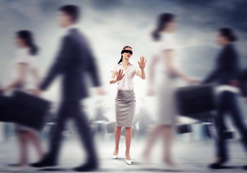 Image of businesswoman in blindfold walking among group of people