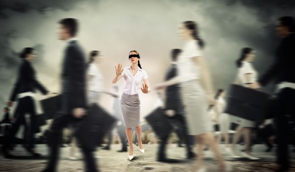 Image of businesswoman in blindfold walking among group of people