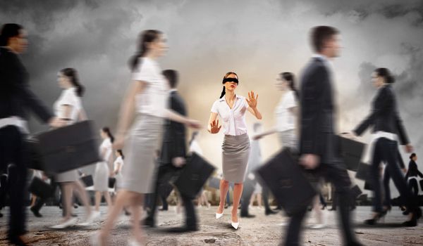 Image of businesswoman in blindfold walking among group of people