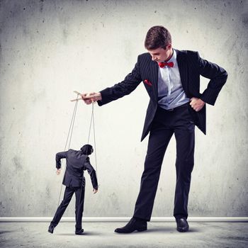 Image of young businessman puppeteer. Leadership concept