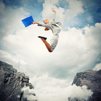 Image of young businesswoman jumping over gap