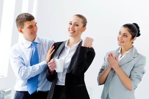 Image of three young businesspeople laughing joyfully