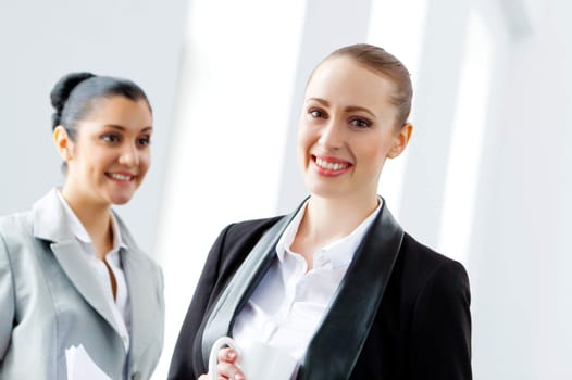 Image of two young pretty businesswomen smiling