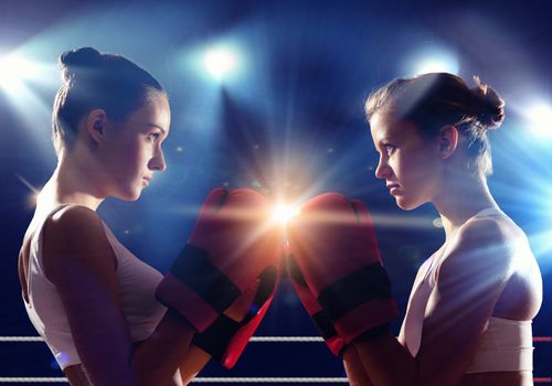 Two young pretty women boxing in ring