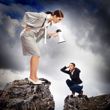 Angry businesswoman with megaphone shouting at colleague