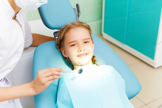 Little girl sitting in the dentists office