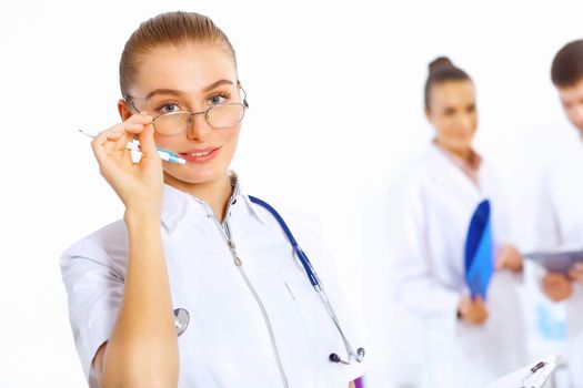 Young female doctor in white uniform with collegues on the background