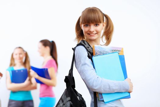 Young female student at college with books