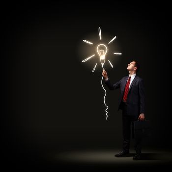 Image of businessman in black suit against dark background