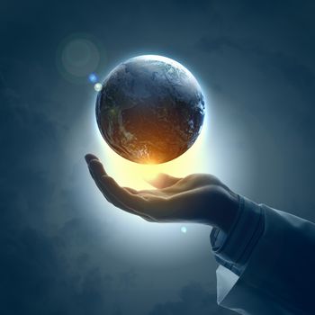 Hand of businessman holding earth planet against illustration background