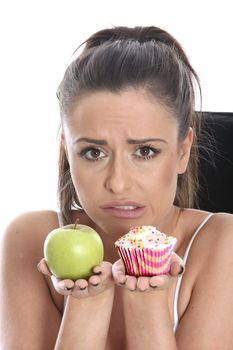 Model Released. Young Woman Comparing Fruit and Cake