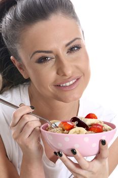 Model Released. Young Woman Eating Porridge and Fresh Fruit