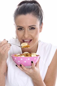 Model Released. Young Woman Eating Breakfast Cereal with Fresh Fruit