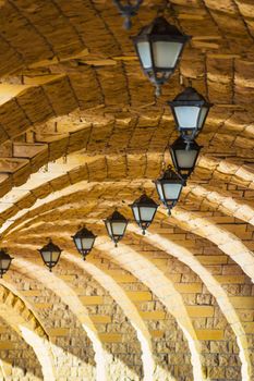 The arched stone colonnade with suspended lanterns