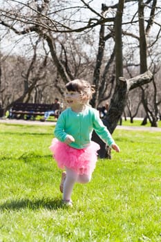 little cheerful girl runs on spring park