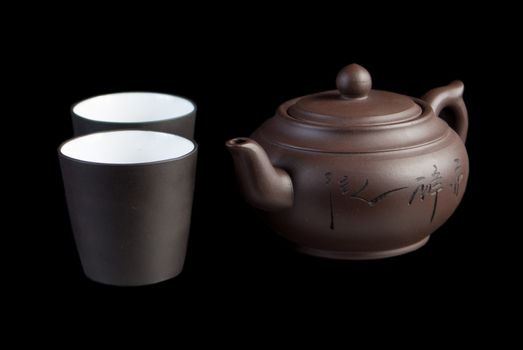 Chinese teapot with teacup on black background