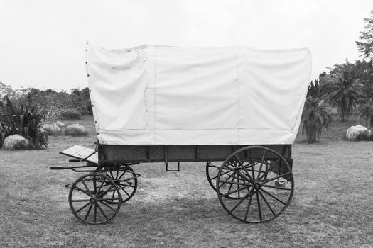 Black & White photo of old wagon wheels Covered wagon  in park