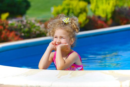 Pretty little girl in swimming pool outdoors