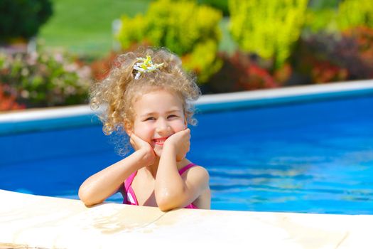 Pretty little girl in swimming pool outdoors