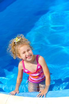 Pretty little girl in swimming pool outdoors