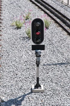 red traffic light on the train tracks