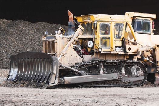 Bulldozer machine doing earth moving work in construction site