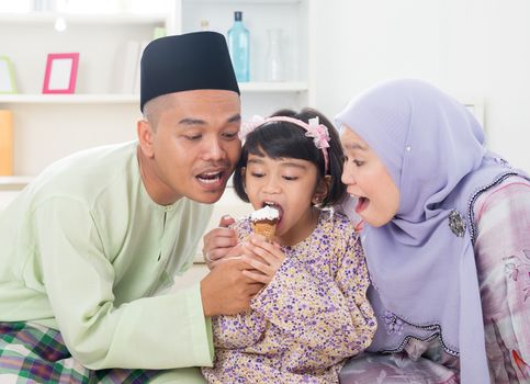Eating ice cream. Muslim family sharing an ice cream. Beautiful Southeast Asian family living lifestyle at home.