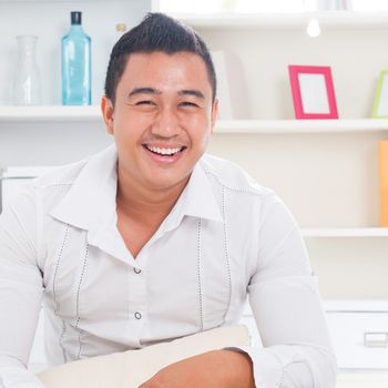 Good looking young Asian man smiling happy. Lifestyle Southeast Asian man at home. Handsome Asian male model.