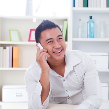 Young Asian man talking on the phone. Lifestyle Southeast Asian man at home. Handsome Asian male model.