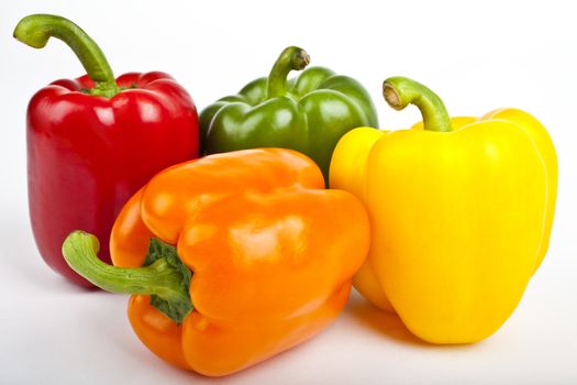 Four Bell Peppers over a white background.