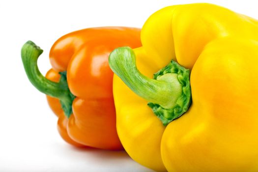 A yellow and Orange Bell Pepper over a white background.