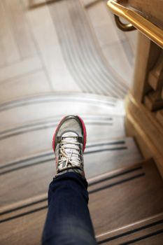 Image of female leg going along marble ladder in office building