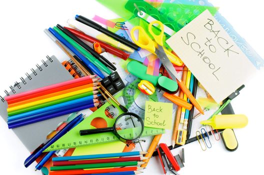 Back to School. Various Stationery Items with Pens, Pencils, Paint Brushes, Felt In Pens, Erasers and Lines on Checked Note Pad isolated on white background