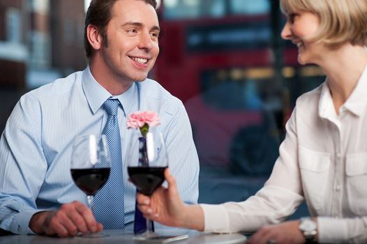 Middle aged couple drinking red wine at an outdoor cafe