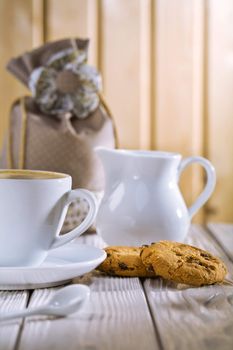 cup spoon cookies jug bag on white old table