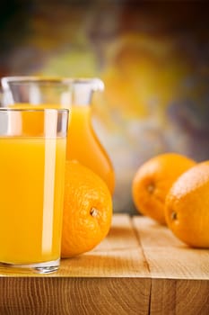 glass with juice and oranges