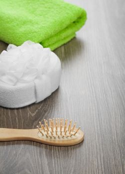 hairbrush and bath sponge with green towel