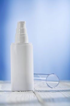 single skincare sprayer on white wooden table