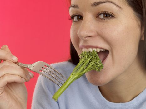 Young Woman Eating Tenderstem Broccoli