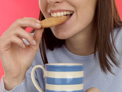 Young Woman Dipping Biscuit Into Hot Drink