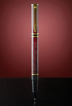 isolated red and golden pen on red background