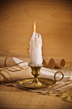 view on the burning candle with old notes sheet