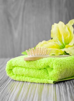 yellow flower on green towel with hairbrush