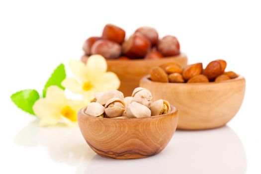 Nuts in a wooden bowl on a white background