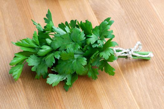 Green parsley lying on a wooden table.