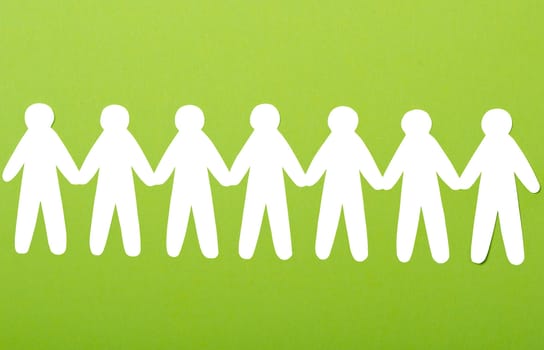 team of paper people on green background