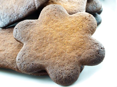 Burned gingerbread cookies on white plate towards white background