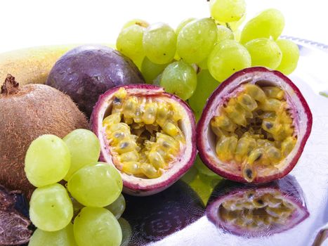 Assorted fruits, isolated on a silver plate, towards white background