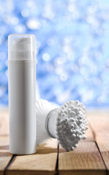 cosmetical spray and cotton swabs on wooden table
